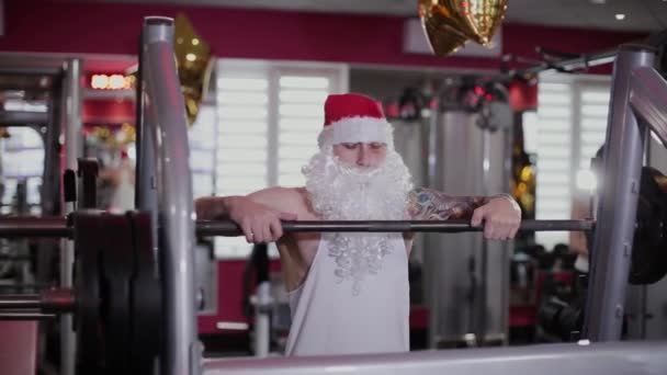 Fitness instruktor Santa Claus v tělocvičně u baru na dřepy. — Stock video