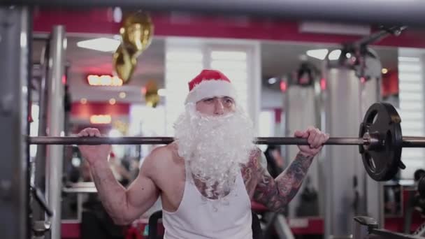 Instructor de fitness Santa Claus en el gimnasio cerca del bar para sentadillas . — Vídeos de Stock