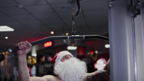 Fitness instruktor Santa Claus v tělocvičně na simulátoru . — Stock video