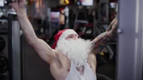 Fitness instruktor Santa Claus v tělocvičně na simulátoru . — Stock video