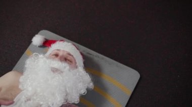 Halı üzerinde dinlenme salonunda fitness eğitmeni Noel Baba.