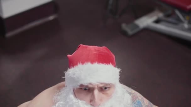 Professeur de fitness Père Noël dans la salle de gym soulève la cloche et les grimaces . — Video