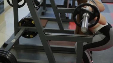 Çok güzel bir kadın ile bir halter onun omuzlarında crouches..