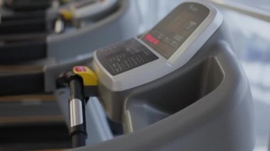 Çok güzel bir kadın spor salonunda bir koşu bandı üzerinde çalıştırmak için hazırlanıyor.