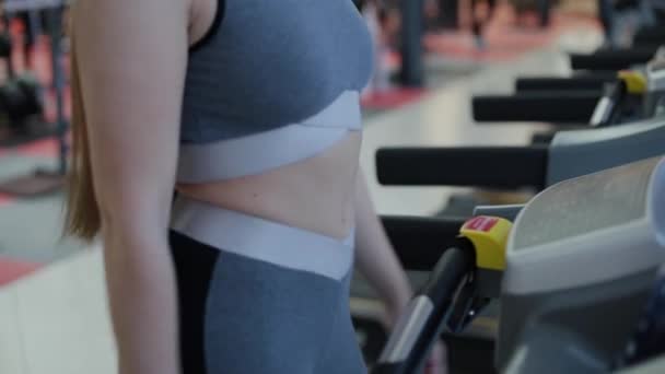 Mujer muy hermosa haciendo ejercicio en la cinta en el gimnasio . — Vídeos de Stock