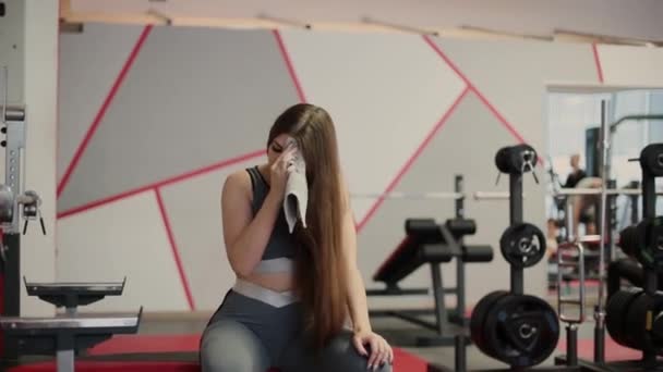 Sehr schöne Frau wischt Schweiß nach dem Training im Fitnessstudio. — Stockvideo