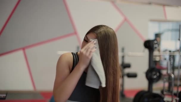 非常に美しい女性のジムでの運動後の汗を拭く — ストック動画
