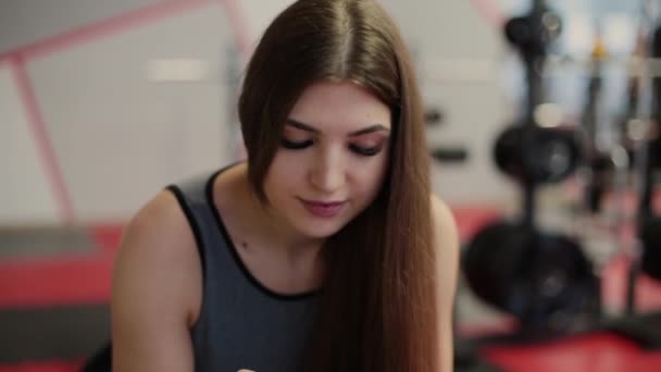 Υγιή γυναίκα ελέγχοντας σώμα στατιστικά στοιχεία σχετικά με έξυπνο τηλέφωνο μετά την προπόνηση στο γυμναστήριο Γυμναστήριο φορετά τεχνολογία. — Αρχείο Βίντεο