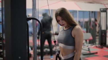 İnce vücut ve simülatör egzersiz yaparak sevimli yüz çekici esmer. Bir kişi 20'li 30'lu tren spor salonu kulüp iç giyim spor ile. Güzellik ve canlılık kurmak. Hızlı nefes.