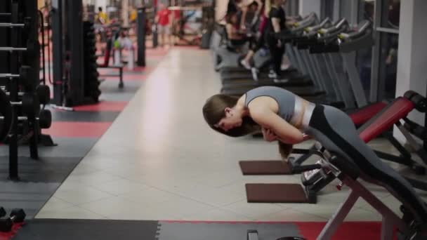 Mujer atlética haciendo hiperextensión en el gimnasio . — Vídeos de Stock