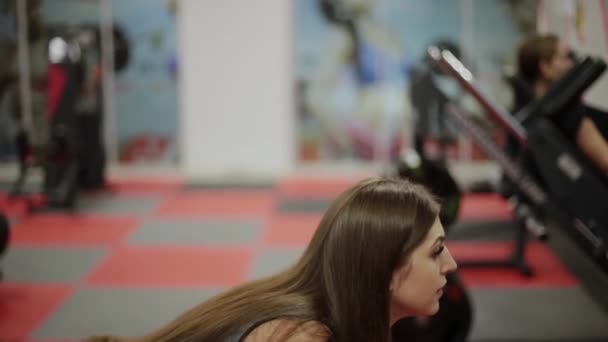 Mujer de fitness muy hermosa haciendo ejercicio con pesas en el gimnasio . — Vídeos de Stock