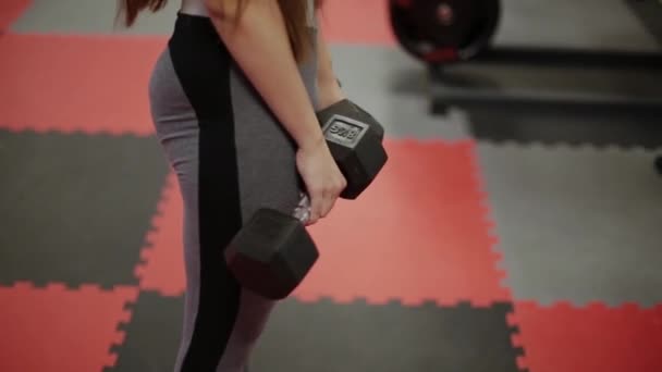 Mujer de fitness muy hermosa haciendo ejercicio con pesas en el gimnasio . — Vídeos de Stock