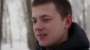 Güzel genç çift konuşmak ve gülümseyen bir şehir kış parkta elele.