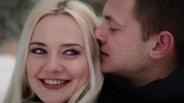 Güzel genç çift sarılma ve bir şehir kış parkı konuşuyor.