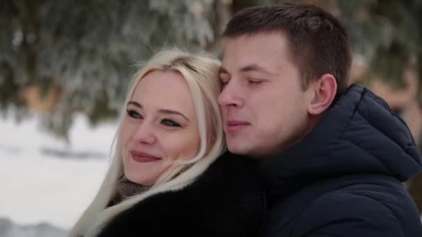 Hermosa pareja joven abrazándose y hablando en un parque de invierno de la ciudad . — Vídeos de Stock