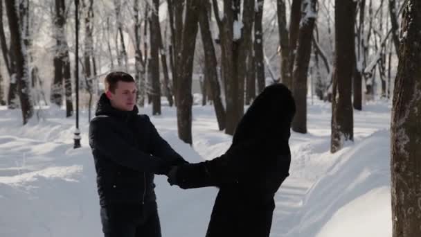 Belo jovem casal de mãos dadas e girando. Parque de inverno da cidade . — Vídeo de Stock