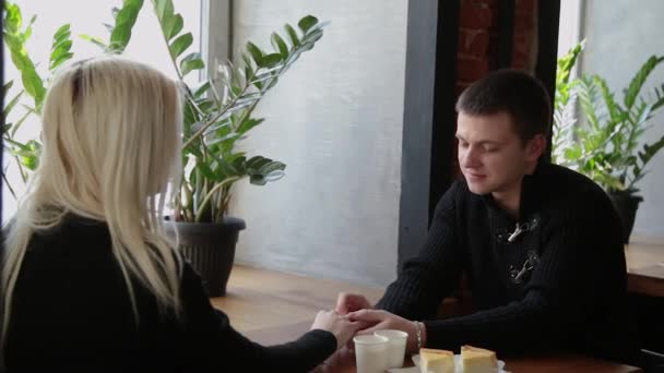 Pareja de amor sentada en un café hablando y mirándose . — Vídeos de Stock