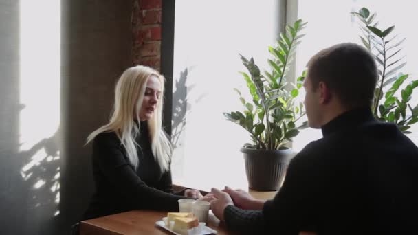 Liefde paar zitten in een cafe praten en kijken naar elkaar. — Stockvideo