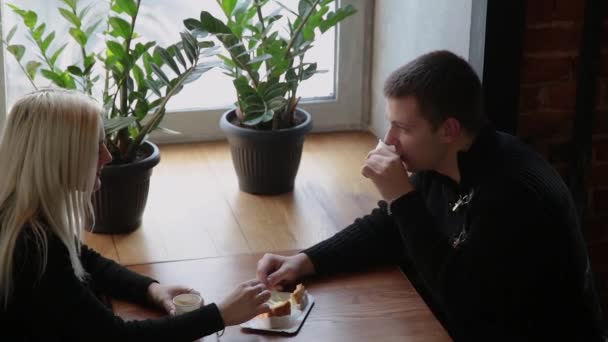Αγάπη ζευγάρι κάθεται σε μια καφετέρια που τρώει το επιδόρπιο, πίνοντας καφέ και βλέπουν ο ένας τον άλλον. — Αρχείο Βίντεο