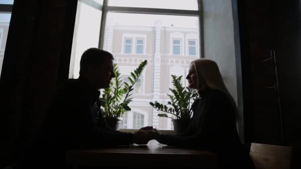 Kärlek paret sitter på ett café talar och tittar på varandra. — Stockvideo