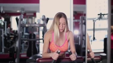 Çok güzel ve seksi fitness model trenler arka uyluk spor salonunda spor salonu makinedeki.
