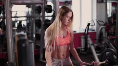 Çok güzel ve seksi fitness modeli bir adam jimnastik salonu için sıra sıkıştırma gerçekleştirmek için yardımcı olur