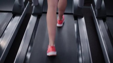 Çok güzel ve seksi fitness modeli spor salonunda treadmill eğitiyor.