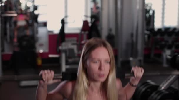 Bardzo piękne i sexy fitness model trenuje nogi z athletic Brzana w siłowni. — Wideo stockowe