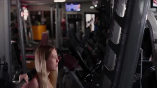 非常美丽和性感的健身模型训练腿与运动杠铃在健身房. — 图库视频影像
