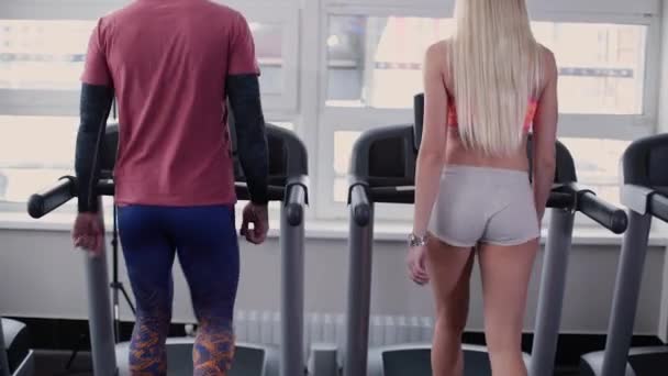 Très beau et sexy modèle de remise en forme et l'homme s'entraînent sur le tapis roulant dans la salle de gym . — Video