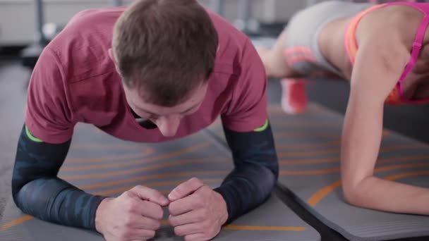 Modelo de fitness muy hermoso y sexy. Hombre deportivo juntos entrenando a la prensa en el gimnasio . — Vídeos de Stock