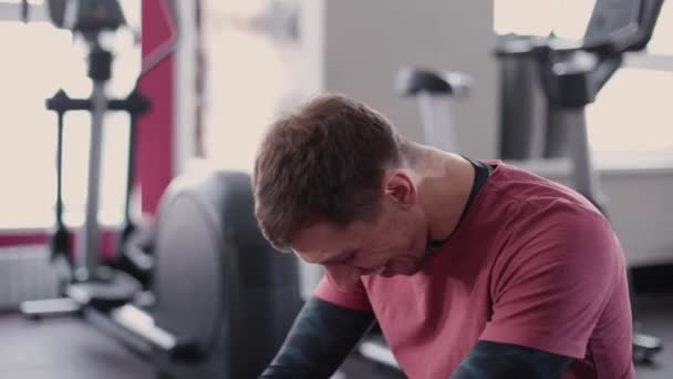 Athlétique et attrayant homme aide une belle femme à s'étirer sur le sol dans la salle de gym . — Video