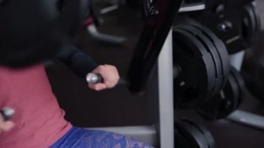 Adam atletik ve çekici bir simülatör spor salonunda göğüs kasları trenler.