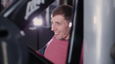 Adam atletik ve çekici bir simülatör spor salonunda göğüs kasları trenler.