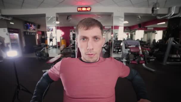 Athletic and attractive man trains pectoral muscles on a simulator in the gym. — Stock Video