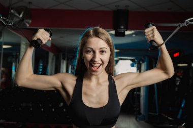 Aktif güzel fitness modeli kız pazı salonunda blokta trenler.