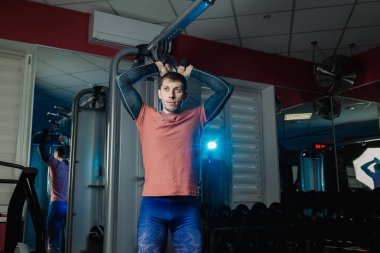 Yakışıklı atletik dayanıklılık spor salonunda blokta trenler.