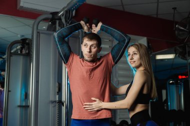 Yakışıklı atletik dayanıklılık spor salonunda bir eğitmen altında belgili tanımlık yardım blokta trenler.