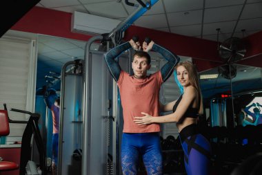 Yakışıklı atletik dayanıklılık spor salonunda bir eğitmen altında belgili tanımlık yardım blokta trenler.