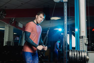 Yakışıklı atletik dayanıklılık spor salonunda blokta trenler.