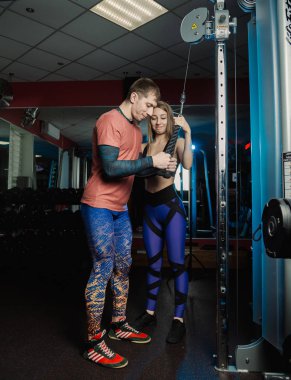Yakışıklı atletik dayanıklılık spor salonunda bir eğitmen altında belgili tanımlık yardım blokta trenler.