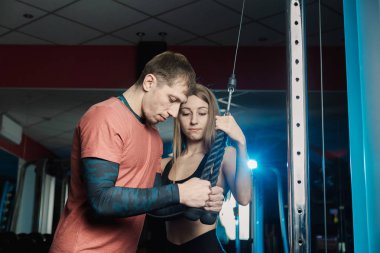 Yakışıklı atletik dayanıklılık spor salonunda bir eğitmen altında belgili tanımlık yardım blokta trenler.