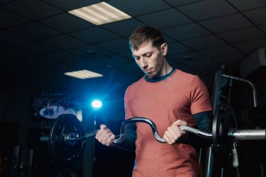 Yakışıklı atletik erkek trenler pazı halter salonunda.