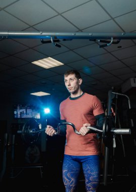 Yakışıklı atletik erkek trenler pazı halter salonunda.