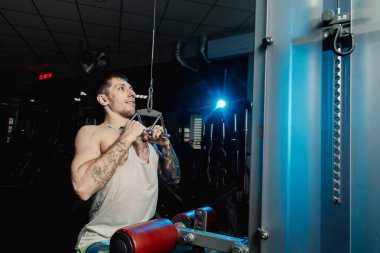 Spor salonunda spor salonu makinedeki çalışma dışarı yakışıklı atletik erkek.