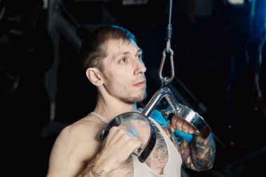 Spor salonunda spor salonu makinedeki çalışma dışarı yakışıklı atletik erkek.