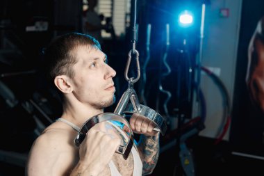 Spor salonunda spor salonu makinedeki çalışma dışarı yakışıklı atletik erkek.