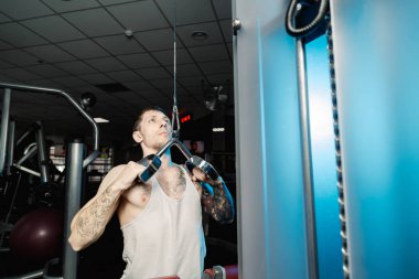 Spor salonunda spor salonu makinedeki çalışma dışarı yakışıklı atletik erkek.