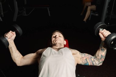 Yakışıklı atletik spor salonunda yalan sırasında halter ıslahı tarafından göğüs kasları trenler.