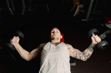 Yakışıklı atletik spor salonunda yalan sırasında halter ıslahı tarafından göğüs kasları trenler.